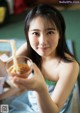 A woman holding a bowl of noodles with chopsticks in it.