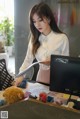 A woman sitting at a desk in front of a computer.