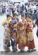 A group of women in kimonos standing next to each other.