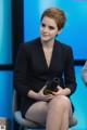 A woman sitting on a chair holding a hair dryer.