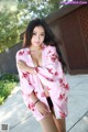 A woman in a pink kimono posing for the camera.