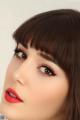 A close up of a woman with long brown hair and red lipstick.