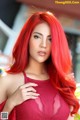 A woman with long red hair posing for a picture.